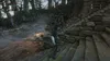 A character in a hooded cloak stands on stone steps in a dark, overgrown forest setting. Náhled obrázku produktu