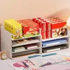 A desk organizer filled with snacks and drinks, with a book open in the foreground. Produktbild-Vorschau