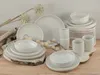 A set of white ceramic dishes and cups arranged on a wooden surface with decorative dried flowers and birch branches. Náhľad obrázku produktu