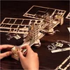 Hands assembling a wooden 3D puzzle of the Tower Bridge on a wooden table. Anteprima dell’immagine prodotto