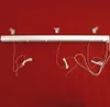 A white roller blind mechanism with cords is mounted on a red wall. Produktbild-Vorschau