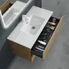 A modern bathroom vanity with a sink and an open drawer filled with toiletries and makeup. Produktbild-Vorschau