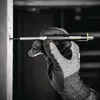 A gloved hand is using a marking pencil to make a mark on a wooden surface. Produktbild-Vorschau