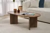 A living room scene with a coffee table in the foreground and a sofa in the background. Produktbild-Vorschau