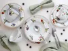 A flat lay of a fruit-themed dinnerware set. Produktbild-Vorschau