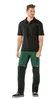 A man wearing work pants and a polo shirt, standing against a white background. Produktbild-Vorschau