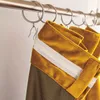 Close-up of yellow and green curtains hanging from a metal rod. Anteprima dell’immagine prodotto