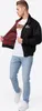 A man wearing a black jacket and blue jeans, posing against a white background. Produktbild-Vorschau