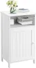 A white bathroom cabinet with a door and an open shelf, decorated with a vase of flowers and books on top. Produktbild-Vorschau