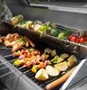 A variety of foods, including chicken, sausages, vegetables, and fruit, are being grilled on a gas grill. Produktbild-Vorschau