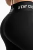 Close-up view of the back of black leggings with text on the waistband. Produktbild-Vorschau