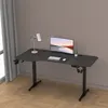 A black adjustable height desk with a monitor, keyboard, mouse, lamp, and headphones. Produktbild-Vorschau