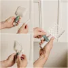 Collage of hands demonstrating how to use a litter scoop with a built-in bag dispenser. Voir les images du produit