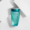 A bottle of Kérastase shampoo is displayed against a backdrop of white geometric shapes. Podgląd zdjęcia produktu