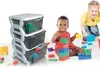 Two children are playing with building blocks next to a storage drawer unit. Anteprima dell’immagine prodotto