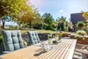 A table set for outdoor dining with chairs, a pitcher of water, glasses, and flowers. Produktbild-Vorschau