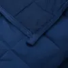 A close-up view of a quilted blue blanket. Náhľad obrázku produktu