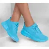 A pair of blue Skechers sneakers worn by a person. Podgląd zdjęcia produktu