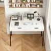 A modern white desk with black legs, featuring a digital clock, keyboard, and lamp. Podgląd zdjęcia produktu