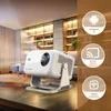 A white projector is placed on a table in a modern living room setting. There are circular icons on the right side of the image highlighting features. Voir les images du produit