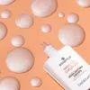 A bottle of essence highlighting drops surrounded by droplets of the product on an orange background. Voir les images du produit