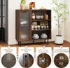A sideboard cabinet with a glass door, shelves, and wine glass holders, shown in a room setting with decorative items and a plant. Below the cabinet are four numbered sections highlighting product features with text and close-up images. Náhľad obrázku produktu
