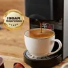 A close-up shot of a coffee machine brewing espresso into a white cup, with a marketing badge indicating '19BAR Espresso'. Produktbild-Vorschau