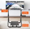 A racing wheel stand is shown in a living room setting with a TV in the background. Anteprima dell’immagine prodotto