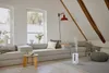 A humidifier is shown in a cozy living room setting with a built-in sofa and large windows. Náhled obrázku produktu