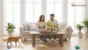 A couple is sitting on a couch, holding and looking at pet products on a coffee table. A cat is walking on the floor in front of the couch. Anteprima dell’immagine prodotto