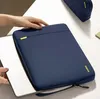 A person's hands are shown interacting with a navy blue laptop sleeve on a white surface, with a laptop partially inserted. Produktbild-Vorschau