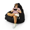 A boy is playing a video game while sitting on a large black beanbag chair. Podgląd zdjęcia produktu