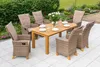 An outdoor patio setting with a wooden table and six chairs, surrounded by greenery and flowers. Náhled obrázku produktu