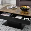 A close-up view of a coffee table with open storage compartments, showing magazines and a game controller. Anteprima dell’immagine prodotto