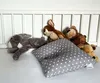 Several stuffed animals and a pillow are arranged in a crib. Produktbild-Vorschau