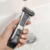 A hand holding a Philips bodygroomer under running water in a sink. Podgląd zdjęcia produktu