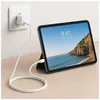 An iPad is charging on a wooden desk, plugged into a wall socket. Anteprima dell’immagine prodotto