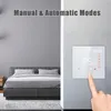 A smart thermostat is shown on a wall next to a bed in a bedroom. The thermostat displays the temperature and time. Podgląd zdjęcia produktu