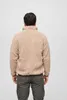A person wearing a beige fleece jacket and grey pants, shown from the back against a white background. Anteprima dell’immagine prodotto