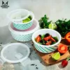 A set of glass food containers with lids, some filled with salad and lime, arranged on a surface with fresh ingredients. Produktbild-Vorschau