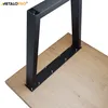 A close-up view of black metal table legs attached to a wooden tabletop. Voir les images du produit