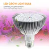 A close-up of an LED grow light bulb with plants in the background, illuminated by pink light. Produktbild-Vorschau
