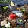 Grauer Camping-Topf und -Pfanne mit neongrünen Griffen beim Kochen über einem roten MSR-Campingkocher im Freien Anteprima dell’immagine prodotto