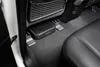 A compact subwoofer is installed under the passenger seat of a car. Produktbild-Vorschau