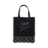 A black tote bag with white embroidery. Voir les images du produit