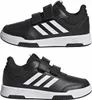 A pair of black Adidas children's sneakers with white stripes and velcro straps, shown from a side view. Podgląd zdjęcia produktu