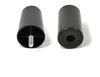 Two black cylindrical furniture feet are shown against a white background. One foot is shown from the bottom, revealing a threaded bolt and internal support structure. The other foot is shown from the top, revealing a hexagonal recess. Voir les images du produit