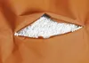 A close-up view of a torn orange fabric revealing white filling material. Náhled obrázku produktu