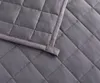 A close-up view of a quilted gray blanket. Podgląd zdjęcia produktu