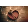 A heart-shaped box with a key and fairy lights on a wooden surface. Produktbild-Vorschau
